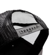 Black Fuel DEPARTURE Trucker Hat with a curved brim and white mesh back, featuring an embroidered logo on the front.