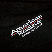 Black American Racing SPORT Polo with embroidered logo, short sleeves, and a classic collar.