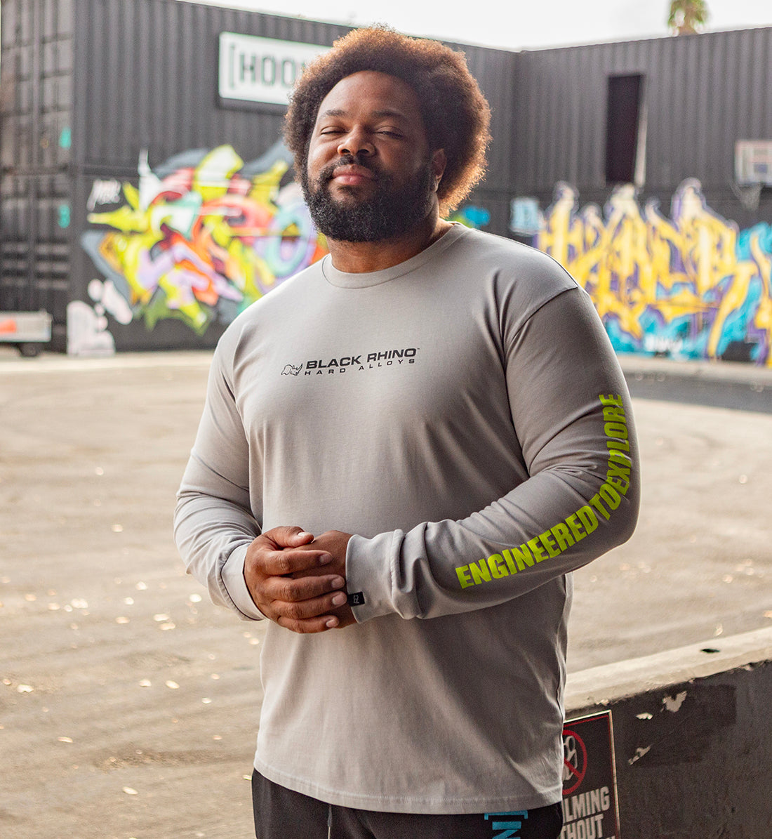 Black Rhino CORE Long Sleeve Tee in grey, featuring a round neckline and branded logo on the chest, displayed in a lifestyle setting.