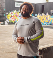 Black Rhino CORE Long Sleeve Tee in grey, featuring a round neckline and branded logo on the chest, displayed in a lifestyle setting.