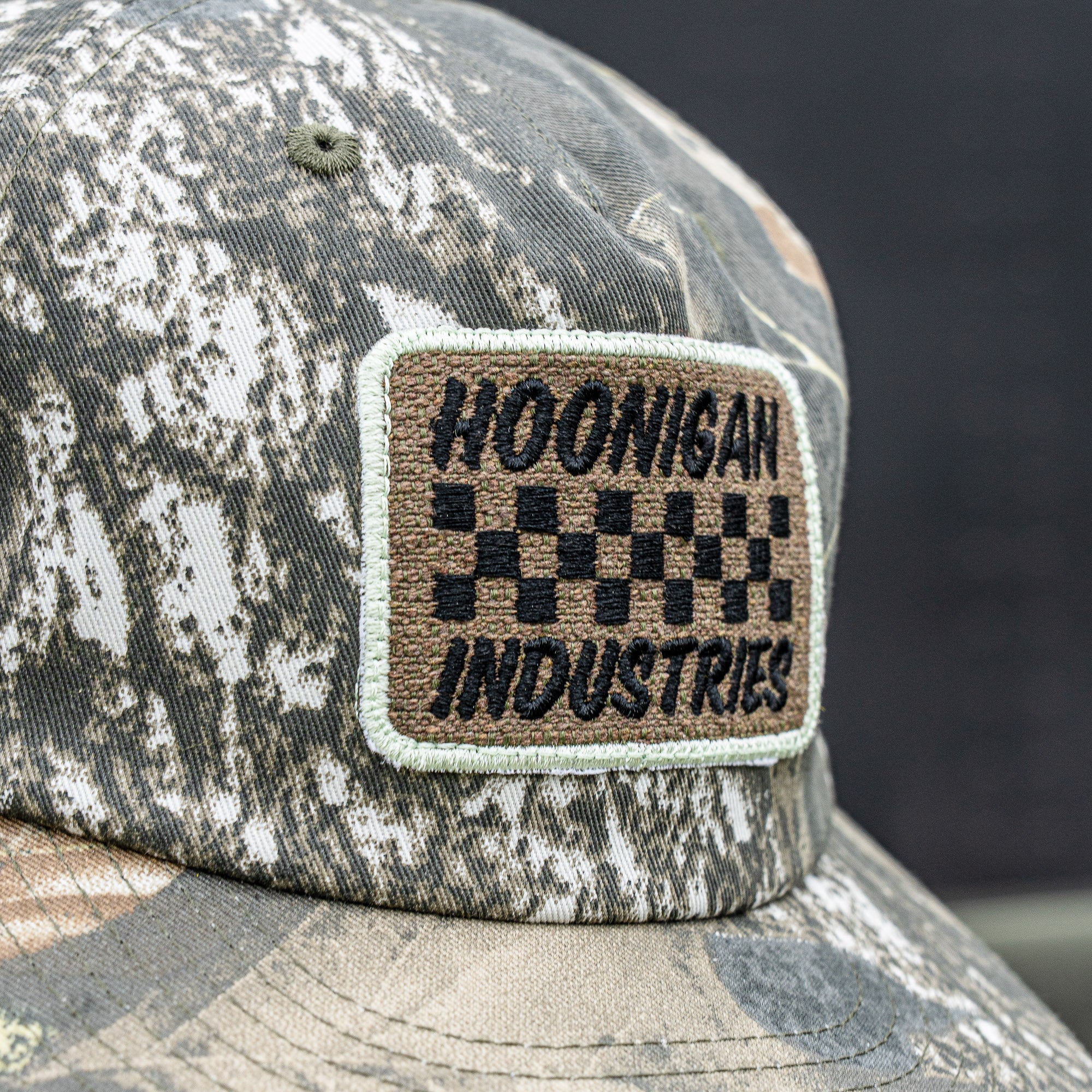 Hoonigan SPRINT unstructured snapback hat featuring a camo pattern and embroidered logo patch. Ideal for motorsport fans.