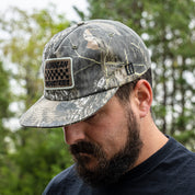 Hoonigan SPRINT unstructured snapback hat in camo design worn by a man outdoors, showcasing its stylish and rugged appeal.