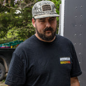 Hoonigan SPRINT unstructured snapback hat worn by a man, featuring a camouflage design and logo, ideal for car enthusiasts.