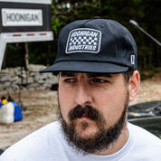 Hoonigan SPRINT unstructured snapback hat worn by a man with a beard, featuring a logo on the front.