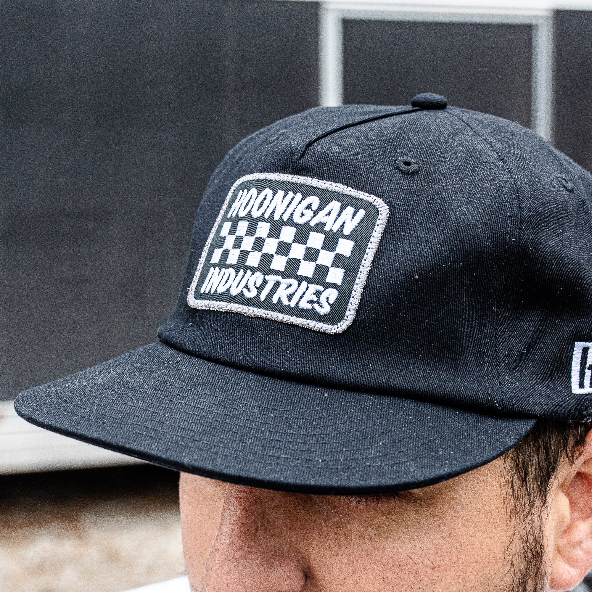 Hoonigan SPRINT unstructured snapback hat featuring a checkered logo and adjustable strap for a casual, stylish look.