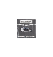 Hoonigan X Leen Customs PROJECT RONNI collectible enamel pin featuring a stylized car design on a black background.