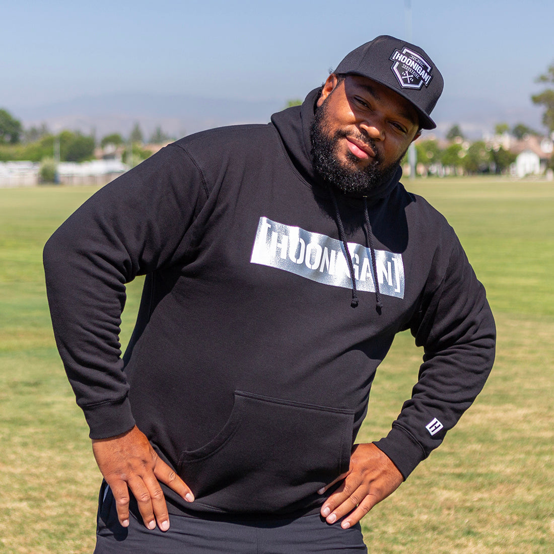 Hoonigan GAME DAY black hoodie featuring a stylish pullover design, model wearing it in an urban outdoor setting.