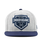 Hoonigan BRACKET X LOGO Snapback Hat in black with white logo detail on the front, featuring an adjustable strap and flat brim design.