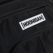 Hoonigan METAL BAR Backpack featuring a rugged black design, adjustable straps, and a prominent logo on the front.