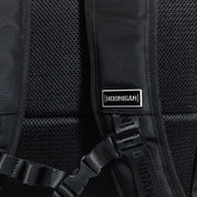 Hoonigan METAL BAR Backpack featuring a sleek black design with a front mesh pocket and adjustable straps.
