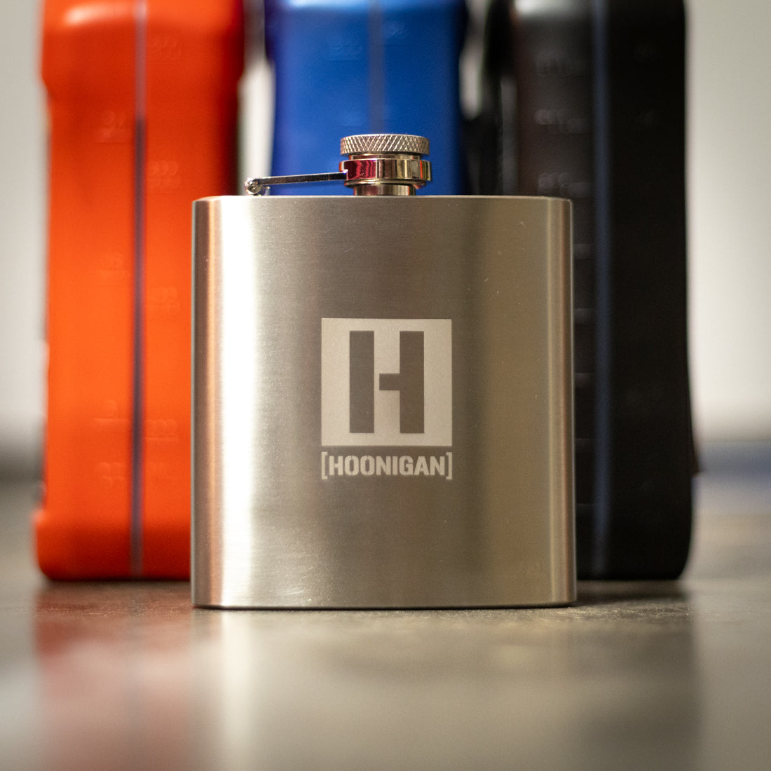 Hoonigan H BOX 6oz stainless steel flask with a matte black finish and Hoonigan logo.
