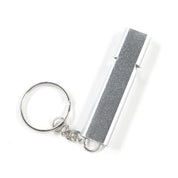 Silver safety keychain with a glittery strip, part of the Hoonigan OH SH*T Safety Kit, designed for emergency use.