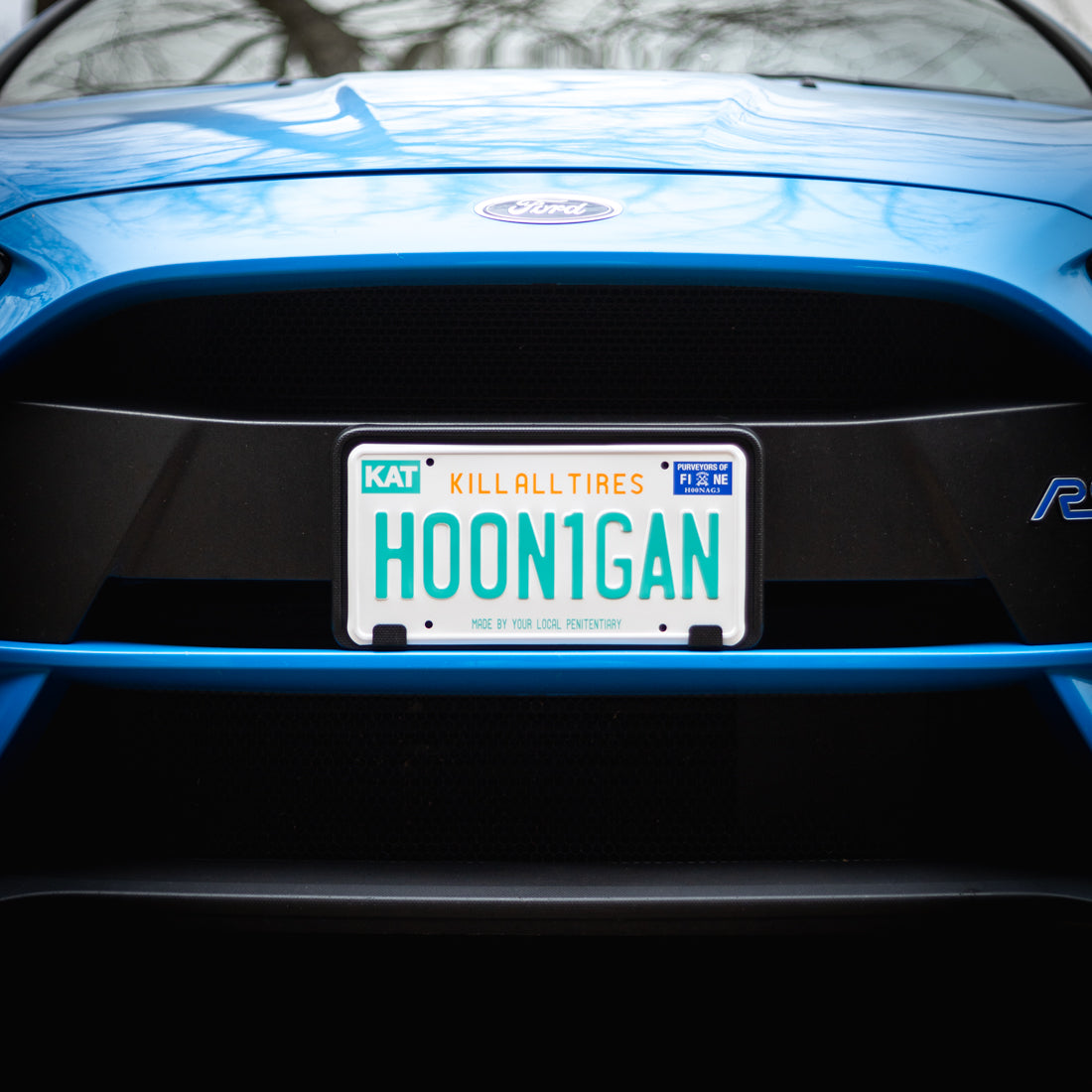 Hoonigan OG FLORIDA License Plate featuring a bold graphic design with the word "Hoonigan" in vibrant colors on a yellow background.