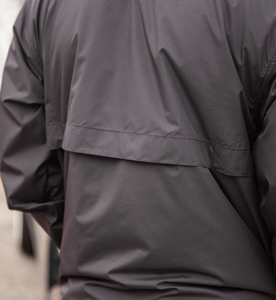 Hoonigan STANDARD ISSUE black and white windbreaker jacket displayed from the back, featuring a stylish design and logo detail.