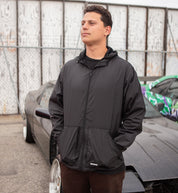 Hoonigan STANDARD ISSUE Windbreaker Jacket in black and white, showcasing a front view with logo detailing and a stylish, casual design.