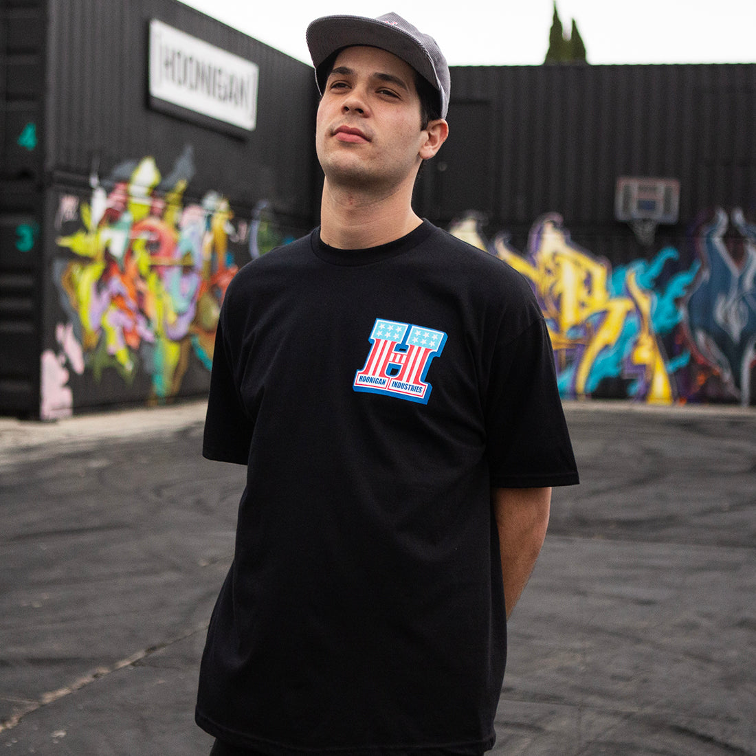 Hoonigan HARDTAIL short sleeve tee in black, worn by a model in an urban setting, showcasing a graphic logo on the front.