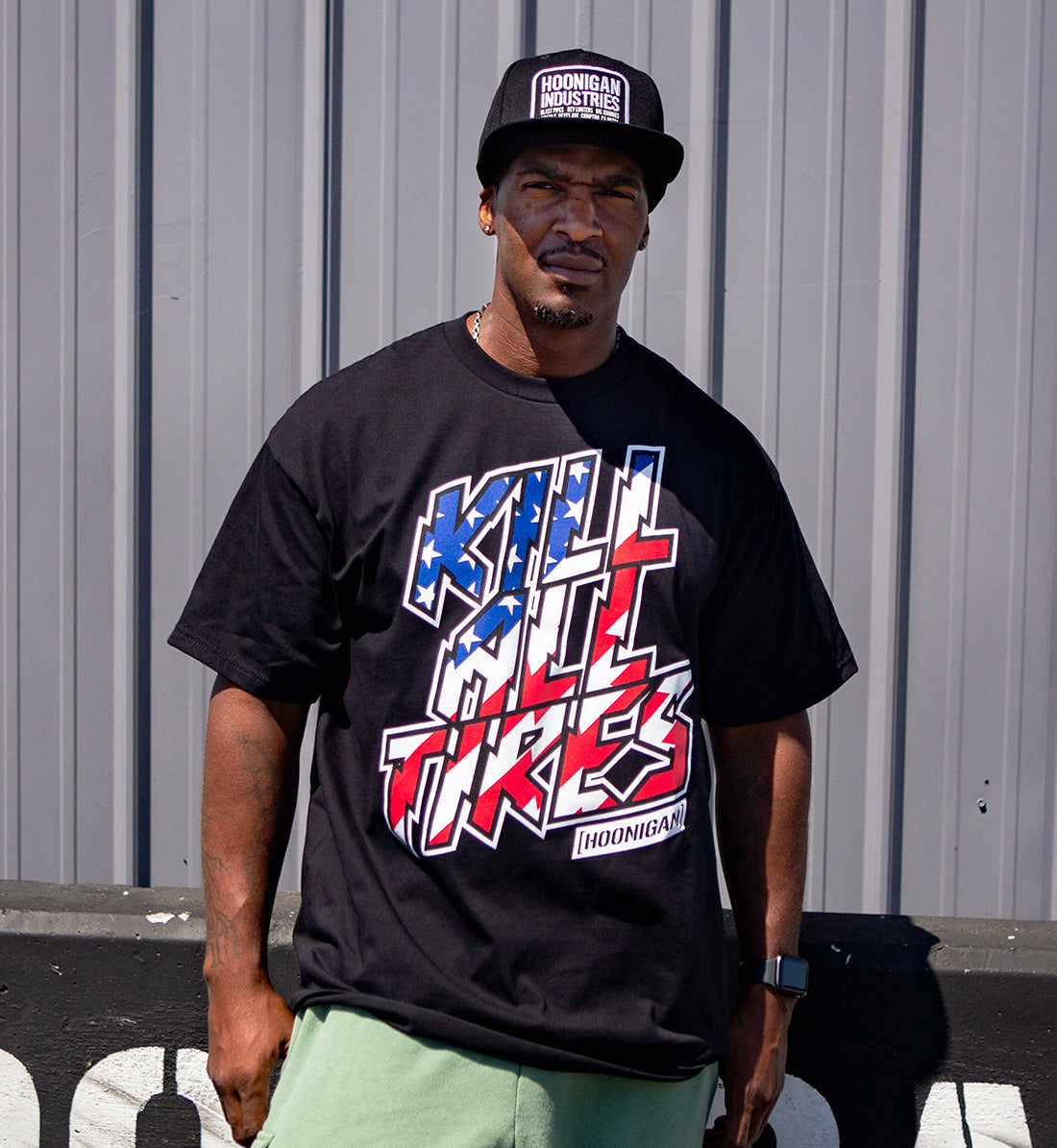 Black short sleeve tee featuring the Hoonigan "KILL ALL TIRES" graphic with stars and stripes design on the front.