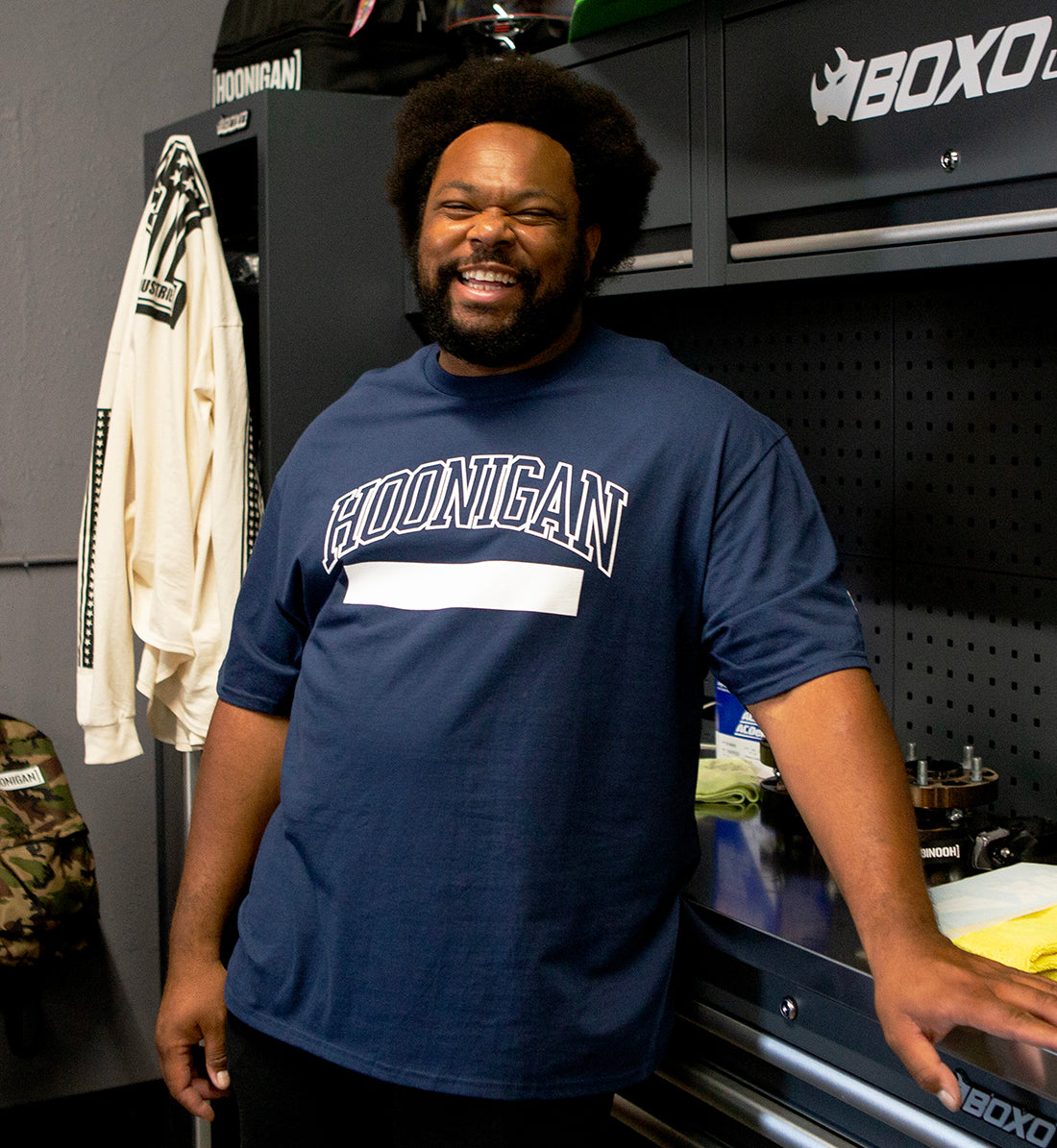 Hoonigan UNATHLETIC Short Sleeve Tee in navy blue, featuring a bold graphic design on the front, worn by a model in a casual setting.