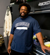 Hoonigan UNATHLETIC Short Sleeve Tee in navy blue, featuring a bold graphic design on the front, worn by a model in a casual setting.