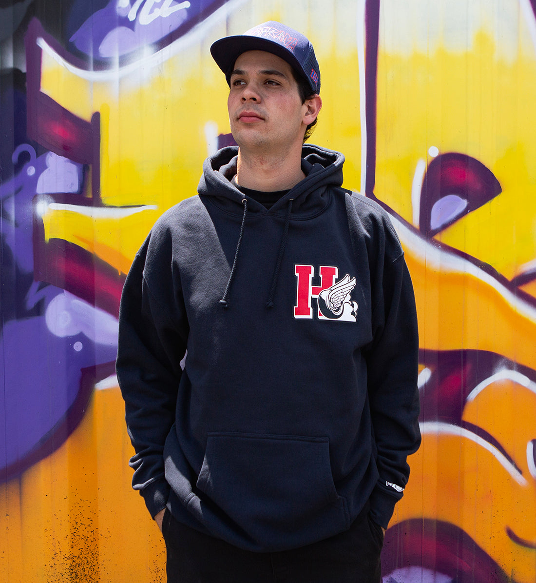 Hoonigan DROP OUT Pullover Hoodie in navy, featuring a front graphic design, relaxed fit, and drawstring hood, modeled in a lifestyle setting.