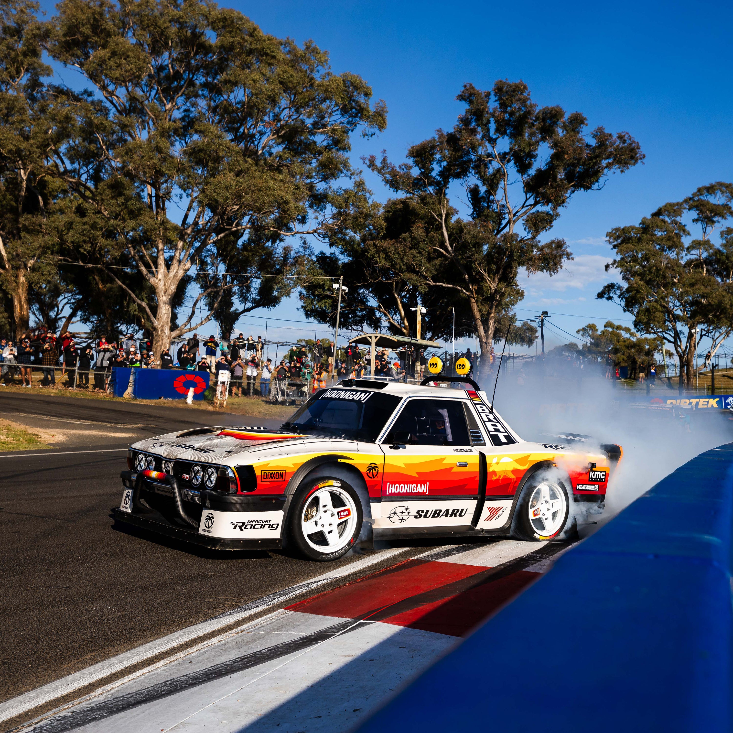 Hoonigan GYMKHANA AUSSIE SHRED BRAT sticker featuring a Subaru car drifting on a racetrack with smoke and spectators.