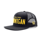 Hoonigan Vintage Plates Trucker Hat, featuring a distressed black front panel with a colorful graphic logo and mesh back, ideal for casual wear.