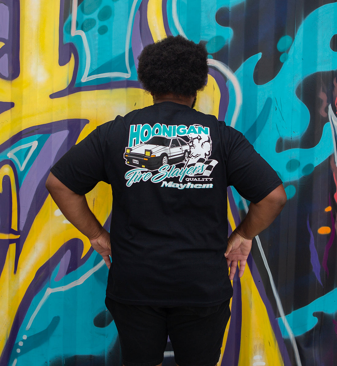 Black short sleeve tee featuring the "Hoonigan 86 TIRE SLAYERS" graphic, showcasing a bold design on the back.