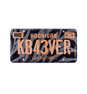 Hoonigan GYMKHANA7 metal license plate featuring a bold graphic design, mainly in black and white, with "GYMKHANA7" text prominently displayed.
