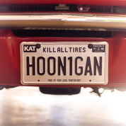 Hoonigan METAL License Plate featuring bold branding and a distressed finish on a black background.