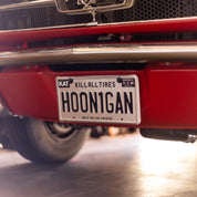 Hoonigan METAL License Plate featuring a bold design with the Hoonigan logo on a textured background.