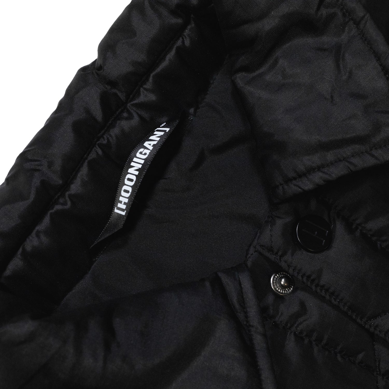 Hoonigan Motorsports VICTOR Quilted Jacket in black, featuring a zip closure, side pockets, and a logo patch on the chest.