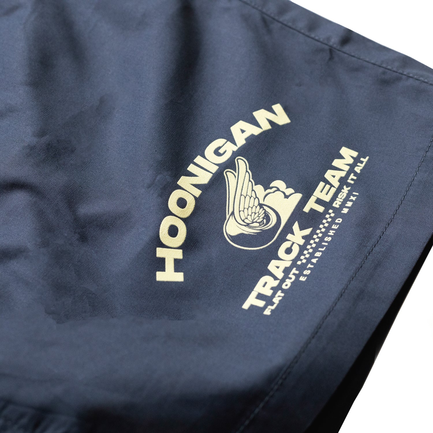 Hoonigan TRACK TEAM Athletic Shorts in black with a white logo, featuring a relaxed fit and drawstring waistband, displayed on a neutral background.