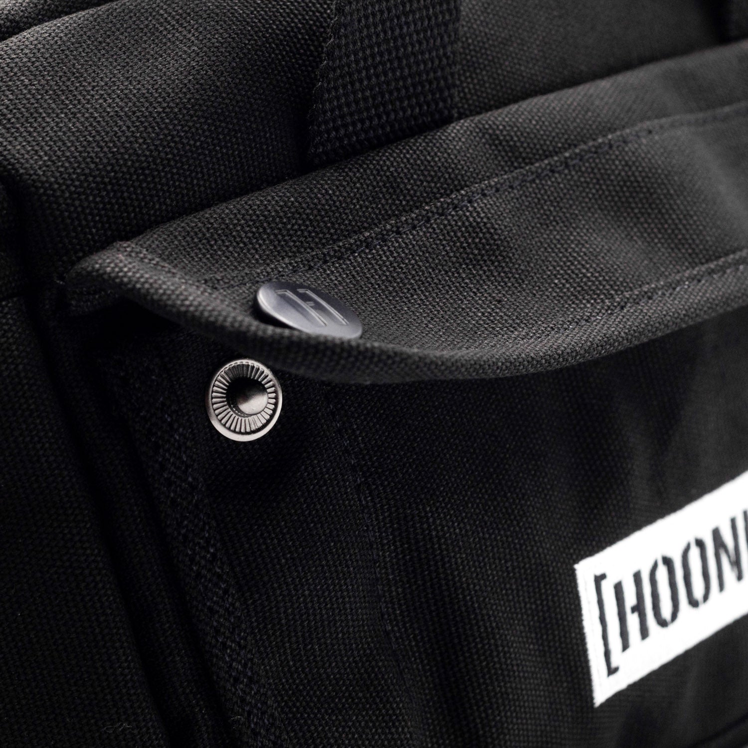 Hoonigan CENSOR BAR Tool Bag in black with Hoonigan logo, featuring multiple pockets and straps for tools and accessories.