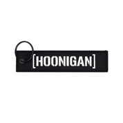 Hoonigan x Sayaka LIFE IS A CHALLENGE Jet Tag Keychain featuring a vibrant design with bold typography on a black background.