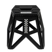 Hoonigan TRACK DAY Collapsible Stool in black with Hoonigan logo, featuring a sturdy frame and convenient carrying handle.