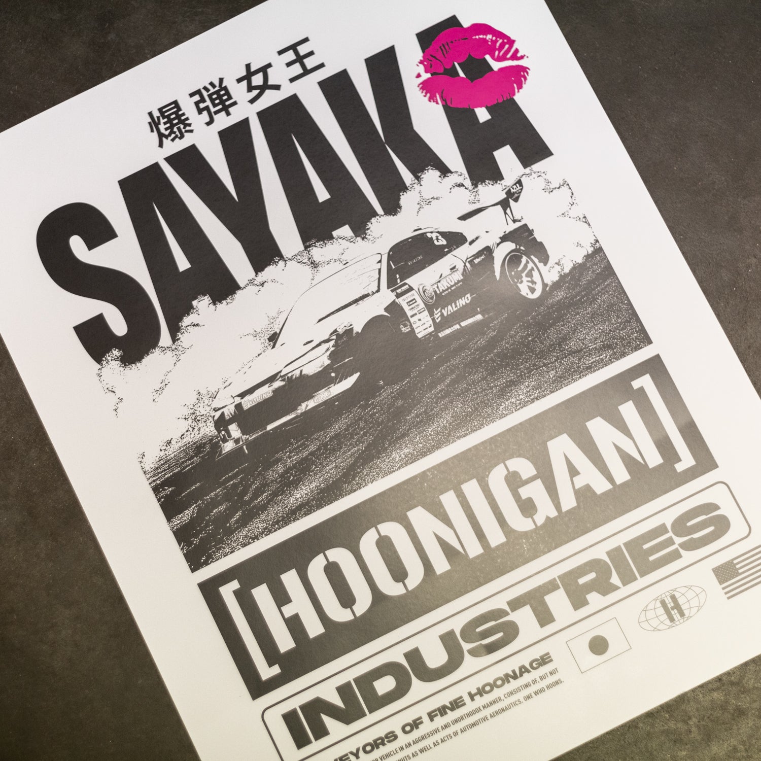 Hoonigan x Sayaka BOMB GIRL 16"x20" poster featuring a vibrant graphic design of a stylized female figure in a dynamic pose, surrounded by colorful elements and bold typography.