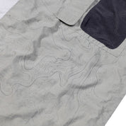Close-up of the Hoonigan H.A.V.O.C. rain-activated windbreaker jacket showing water-sensitive fabric with topographical line design and a black mesh pocket.