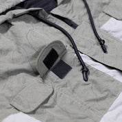 Close-up of the Hoonigan H.A.V.O.C. rain-activated windbreaker jacket showing adjustable velcro strap, drawstrings, and water-resistant fabric.
