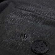 Close-up of Hoonigan Oil Slick Board Shorts featuring a textured logo and subtle sheen for a stylish, sporty look.