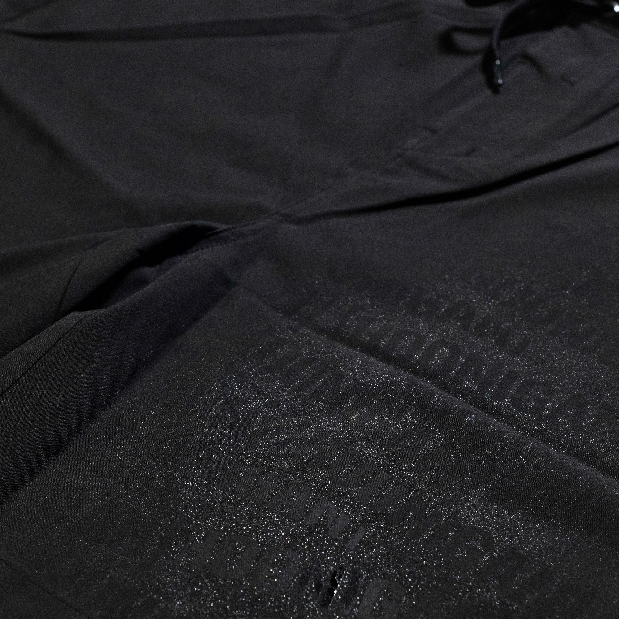 Hoonigan OIL SLICK Board Shorts featuring a sleek black design with a glossy logo print for a stylish look.