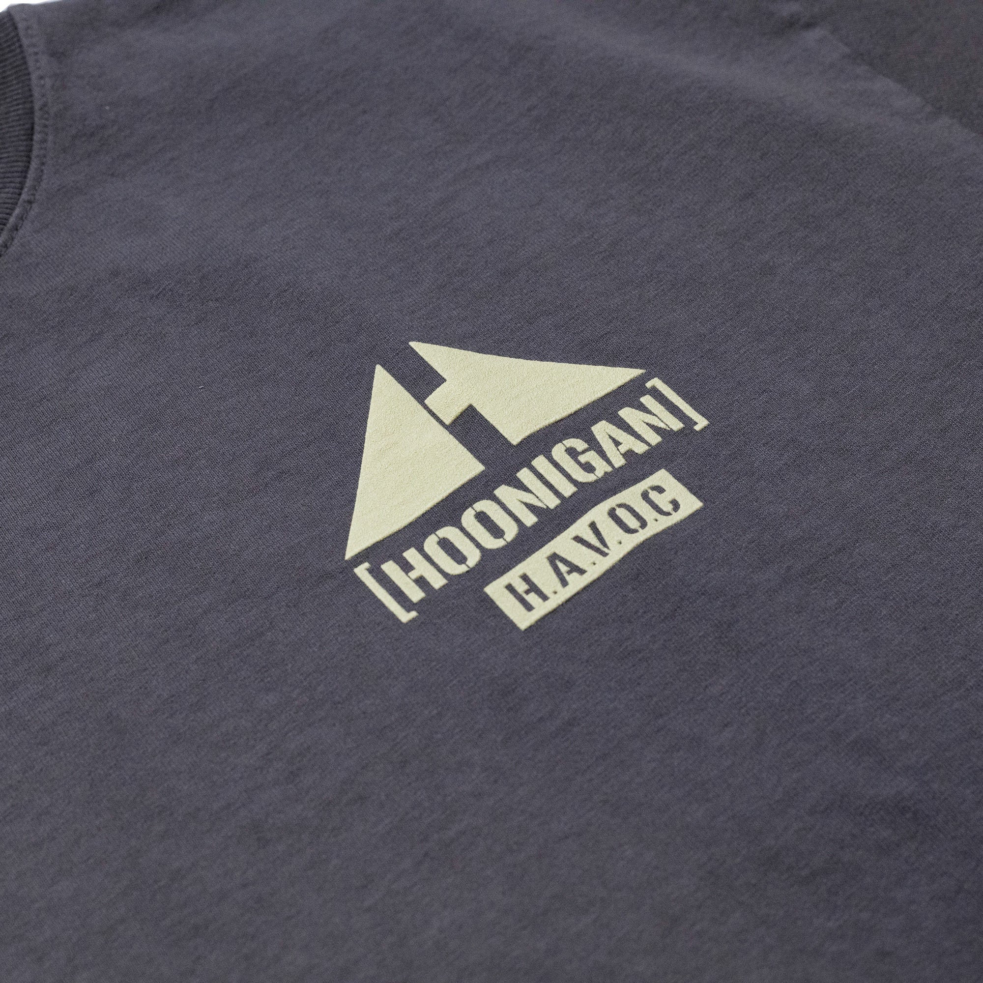 Close-up of a dark gray Hoonigan TOPOGRAHPHIC TERRAIN short sleeve T-shirt with a white printed logo featuring mountain peaks and bold text.