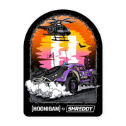 Hoonigan x Shreddy DESERT sticker featuring a vibrant off-road vehicle kicking up dust with a helicopter overhead.