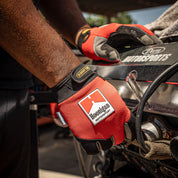 Hoonigan Surgeon General gloves worn by a mechanic working on a car engine, showcasing durability and style.