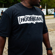 Man wearing the black Hoonigan SHATTERED CENSOR BAR tee, white cracked [HOONIGAN] censor bar logo across the chest.