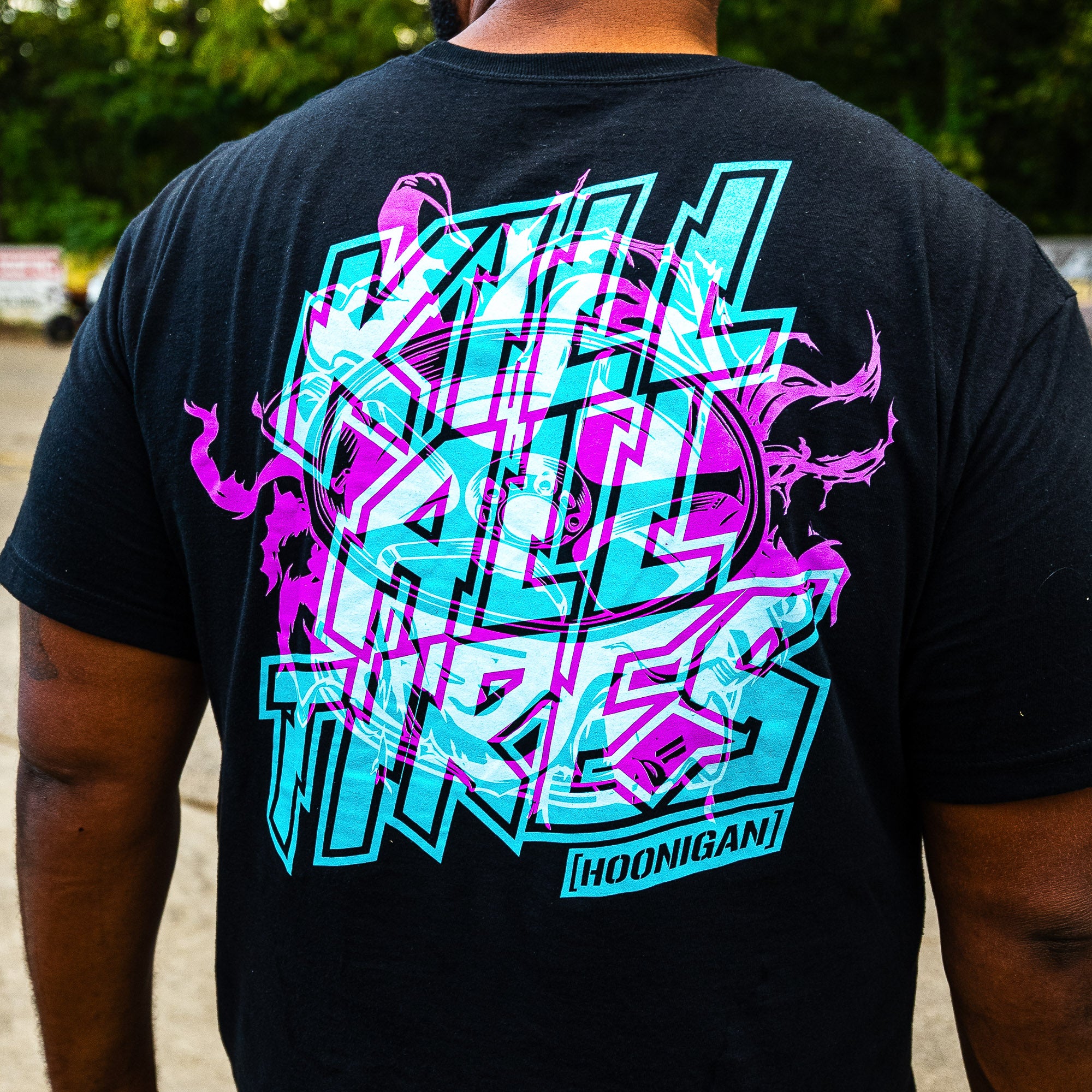 Back of the black Hoonigan TREADWEAR tee with a pink and teal KILL ALL TIRES graphic.