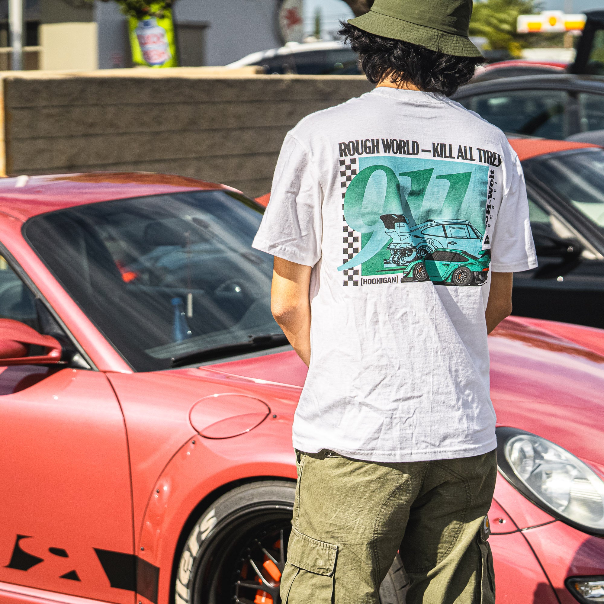 Hoonigan X RWB ROUGH WORLD KILL ALL TIRES Short Sleeve Tee featuring bold graphic design and vibrant colors on a black background.