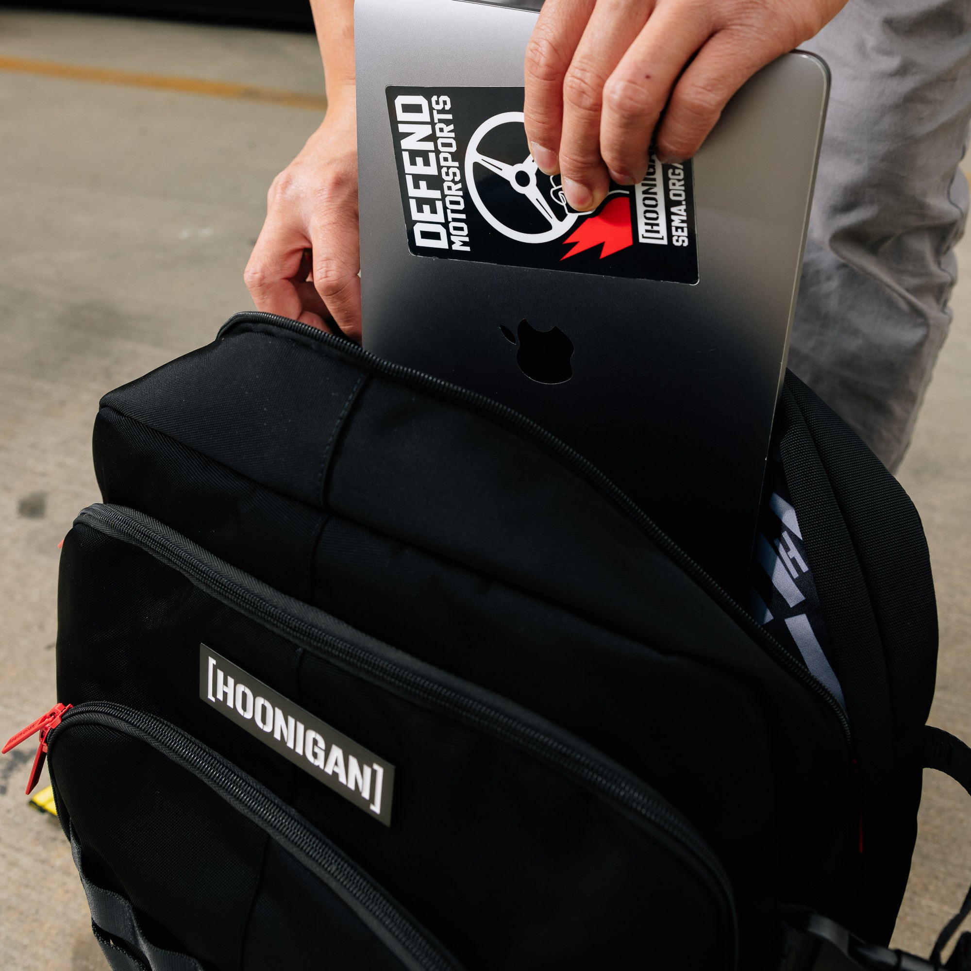 Hoonigan RATCHET STRAP Backpack featuring a durable design with adjustable buckles and a bold logo on a black background.