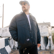 Black Hoonigan Motorsports VICTOR Quilted Jacket with logo on chest, featuring a stylish quilted design and zippered front closure.