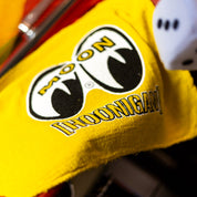 Hoonigan X Mooneyes shop towel featuring a bold yellow design with the Hoonigan and Mooneyes logos, perfect for automotive enthusiasts.