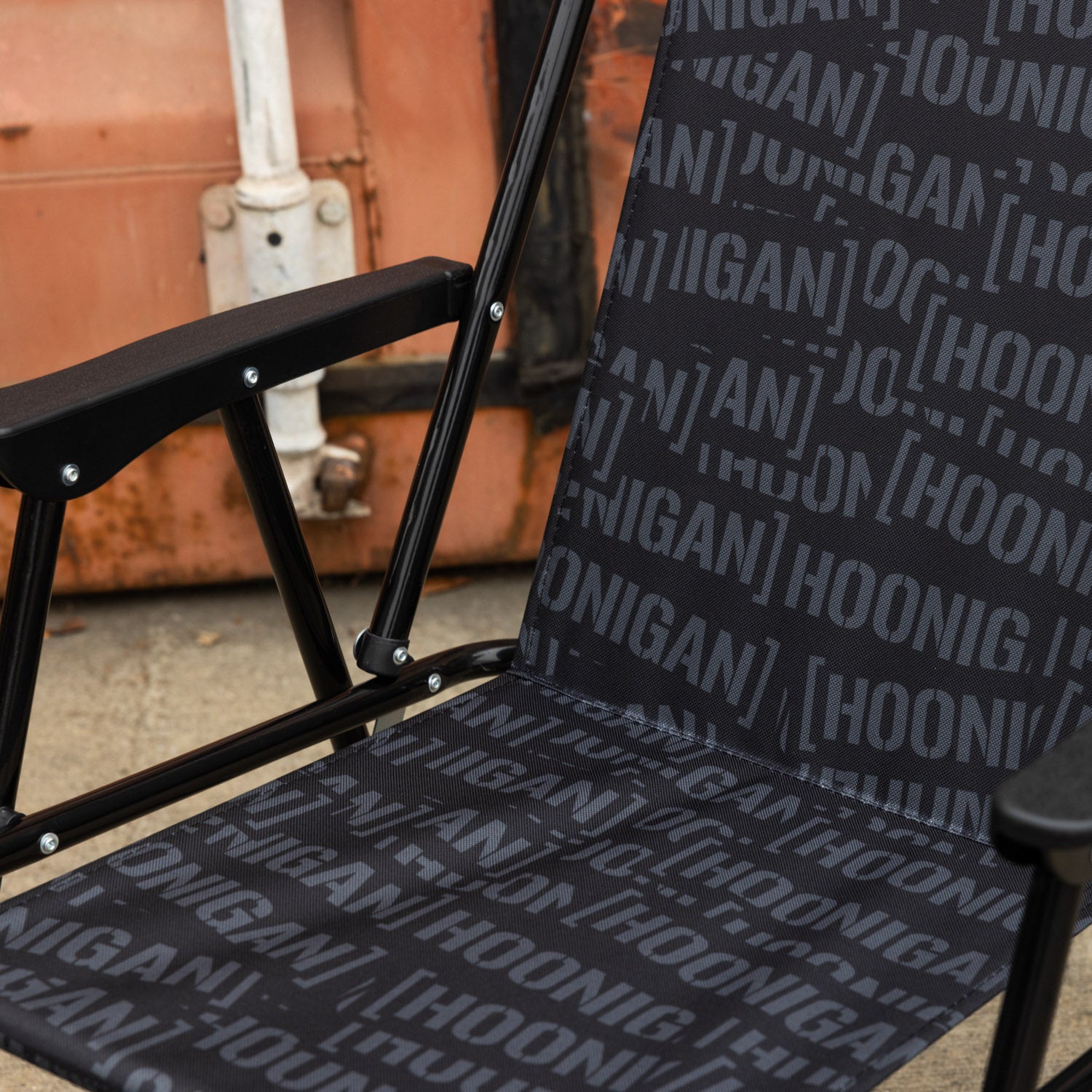 Hoonigan SCATTER CENSOR BAR Collapsible Chair with a black and red design, featuring the Hoonigan logo and an adjustable backrest.